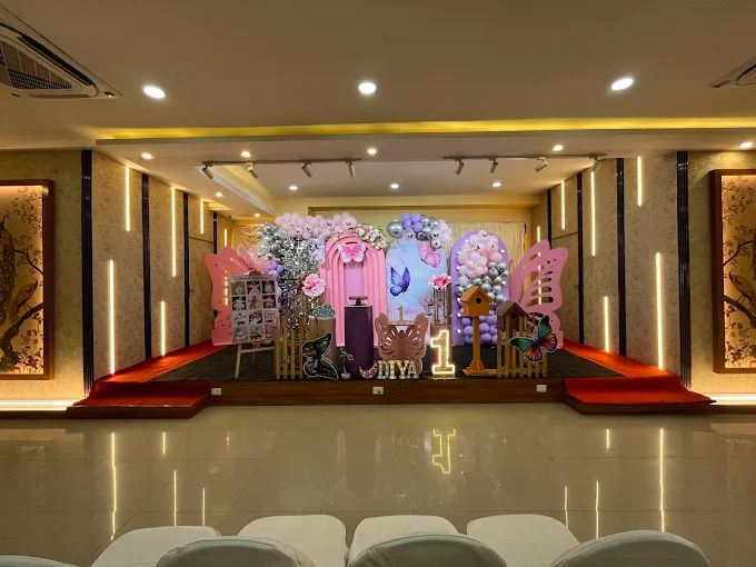 Pastel butterfly-themed first birthday stage with balloon arches