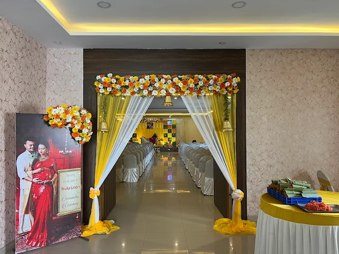 Hall entrance decorated with yellow and white flowers, brass bells and a welcome banner