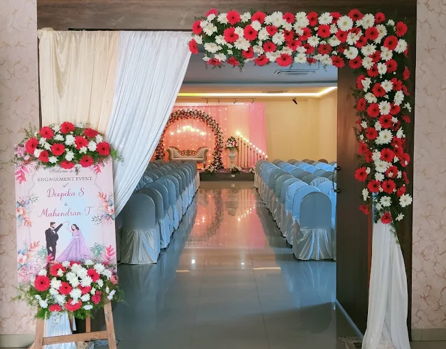 Red and white floral entrance arch leading into an engagement event